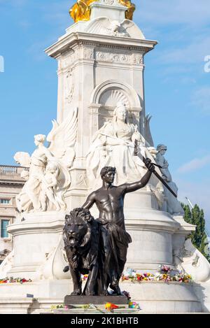 Fiori intorno alla statua di bronzo del Victoria Memorial fuori Buckingham Palace dopo la morte della regina Elisabetta II Bronzo Foto Stock