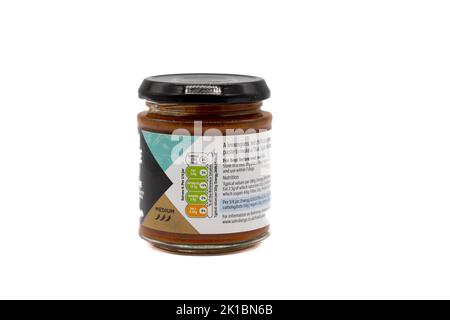 Irvine, Scozia, Regno Unito - 20 agosto 2022: Pasta di curry rossa in vetro riciclabile con marchio Sainsbury, in stile thailandese, con la classificazione media dei simboli e. Foto Stock