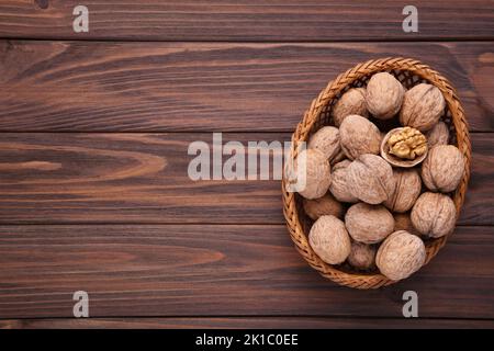 Nocciole in cestello su fondo di legno marrone. Nocciole su tavola di legno grigio Foto Stock