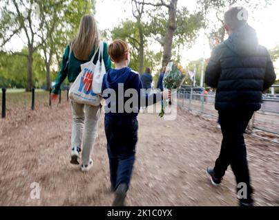 Buckingham Palace, Londra, Regno Unito. 16th Set, 2022. Un ragazzo che porta una poesie di fiori da stendere in memoria della Regina. Le bandiere Union Jack costeggiano il percorso lungo il Mall fino a Buckingham Palace. Una stretta sicurezza è stata imposta in tutto il centro di Londra con una pesante presenza della polizia mentre la città si prepara per i funerali di sua Maestà la Regina Elisabetta II La Regina sarà sepolta lunedì 19th settembre. (Foto di Charlie Varley/Sipa USA) Credit: Sipa USA/Alamy Live News Foto Stock