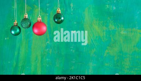 Palle verdi di natale e una rossa su sfondo verde.modello di Natale con grande copia spazio.negativo tecnica spazio. Foto Stock