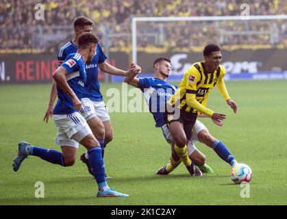 Dortmund, Germania. 17th Set, 2022. Calcio: Bundesliga, Borussia Dortmund - FC Schalke 04, Giornata 7, Signal Iduna Park. Jude Bellingham di Dortmund e Tom Krauß di Schalke cercano di ottenere la palla. Credit: Bernd Thissen/dpa - NOTA IMPORTANTE: In conformità ai requisiti della DFL Deutsche Fußball Liga e del DFB Deutscher Fußball-Bund, è vietato utilizzare o utilizzare fotografie scattate nello stadio e/o della partita sotto forma di sequenze di immagini e/o serie di foto simili a video./dpa/Alamy Live News Foto Stock