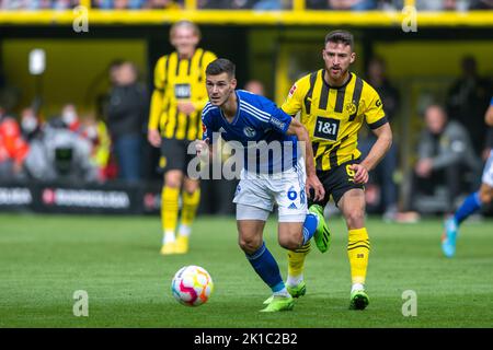 Dortmund, Germania. 17th Set, 2022. Calcio: Bundesliga, Borussia Dortmund - FC Schalke 04, Giornata 7, Signal-Iduna Park: Tom Krauß (l) di Schalke e Salih zcan di Dortmund combattono per la palla. Credit: David Inderlied/dpa - NOTA IMPORTANTE: In conformità ai requisiti della DFL Deutsche Fußball Liga e del DFB Deutscher Fußball-Bund, è vietato utilizzare o utilizzare fotografie scattate nello stadio e/o della partita sotto forma di sequenze di immagini e/o serie di foto simili a video./dpa/Alamy Live News Foto Stock