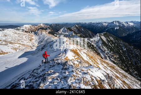 Due arrampicatori sulla stretta cresta rocciosa nevosa del Hochplatte Ammergauer, vista verso Loesertaljoch, vista del panorama di montagna, escursioni al Foto Stock