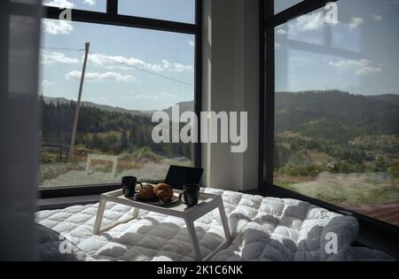 Tavolo per la colazione su un letto con vista panoramica sulle montagne con spazio copia Foto Stock