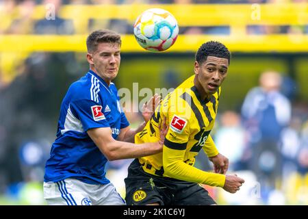 Dortmund, Germania. 17th Set, 2022. Calcio: Bundesliga, Borussia Dortmund - FC Schalke 04, Giornata 7, Signal-Iduna Park: Schalke's Florian Flick (l) e Jude Bellingham di Dortmund combattono per la palla. Credit: David Inderlied/dpa - NOTA IMPORTANTE: In conformità ai requisiti della DFL Deutsche Fußball Liga e del DFB Deutscher Fußball-Bund, è vietato utilizzare o utilizzare fotografie scattate nello stadio e/o della partita sotto forma di sequenze di immagini e/o serie di foto simili a video./dpa/Alamy Live News Foto Stock