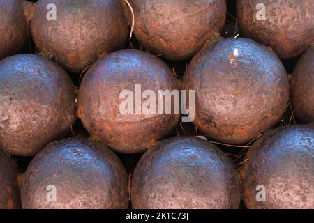 Primo piano di palle di cannone antiche e arrugginite, modello, struttura di palle di cannone a forma di sfera di ferro, una pila di palle di metallo rotonde, munizioni di guerra, sfondo. Foto Stock