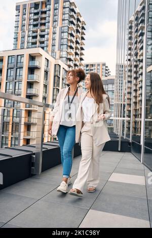 Eleganti donne d'affari che guardano il paesaggio urbano durante la passeggiata per il pranzo Foto Stock