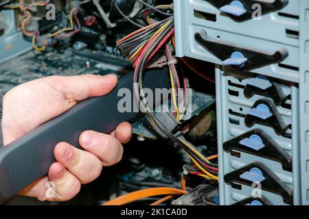 Pulizia dell'unità di sistema di un computer desktop dalla polvere utilizzando un aspirapolvere. Foto Stock