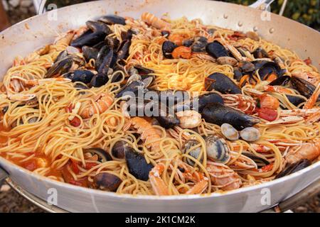 Spaghetti italiani allo scoglio, primi piatti di pasta con frutti di mare e pomodori in padella. Cucina tradizionale mediterranea pugliese con cla stufato fresco Foto Stock