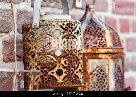 Vecchie lanterne arrugginite su un muro di mattoni ruvidi Foto Stock