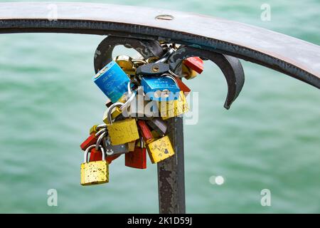 Molti lucchetti su una ringhiera vicino all'acqua come simbolo dell'amore. Foto Stock