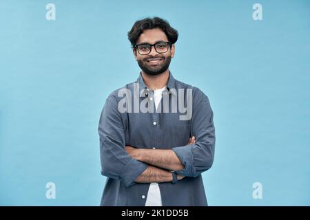 Giovane arabo sorridente e fiducioso in piedi isolato su sfondo blu. Foto Stock