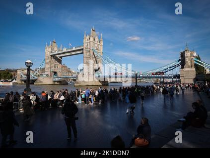 Londra, Regno Unito. 17th Set, 2022. Numerose persone si trovano in una lunga coda sul Tamigi di fronte al Tower Bridge tra l'inizio della coda nel Southwark Park e la Westminster Hall per dire Arrivederci alla bara della Regina Elisabetta II La regina britannica Elisabetta II morì il 08.09.2022 all'età di 96 anni. La bara con la regina è disposta per quattro giorni nel Palazzo di Westminster (Parlamento). Per il 19 settembre è previsto un atto di Stato presso l'Abbazia di Westminster con circa 2000 ospiti e il funerale nel Castello di Windsor con Londra. Credit: Christian Charisius/dpa/Alamy Live News Foto Stock