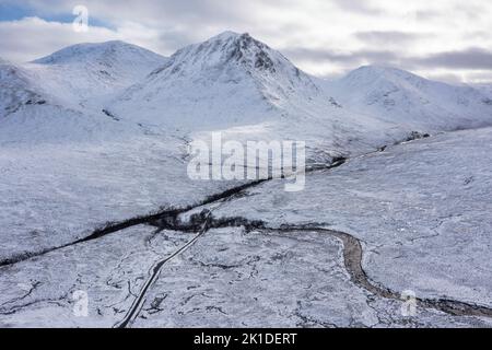 Splendida immagine aerea del paesaggio dei droni di Stob Dearg e Glencoe nelle Highlands scozzesi durante le profonde nevicate e i bellissimi cieli blu Foto Stock