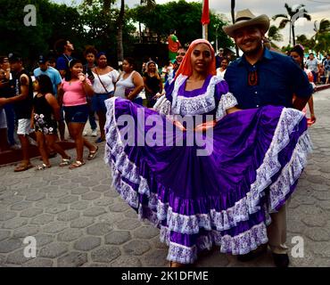 Uomini e donne vestiti tradizionalmente sfilano per le strade di San Pedro, Belize per Noche Centroamericana. Foto Stock