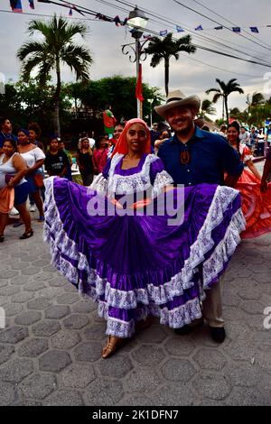 Uomini e donne vestiti tradizionalmente sfilano per le strade di San Pedro, Belize per Noche Centroamericana. Foto Stock