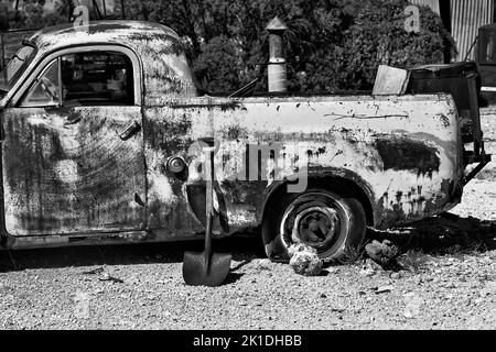 Vecchio veicolo di camion della storia della ruggine bianco-nero a Lightning Ridge, città della miniera opale dell'Outback Australia. Foto Stock