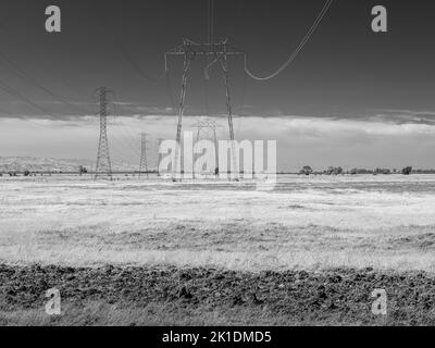 Tower Pylons', linee elettriche che ronziano l'energia elettrica ad alta tensione sul campo, Fairfield, California Foto Stock