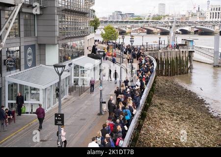 Le persone che si uniscono alle code lungo la riva sud del Tamigi per pagare il loro rispetto per la regina che si trova nello stato presso la sala Westminster di Londra UK Foto Stock