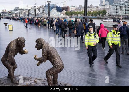 Le persone che si uniscono alle code lungo la riva sud del Tamigi per pagare il loro rispetto per la regina che si trova nello stato presso la sala Westminster di Londra UK Foto Stock