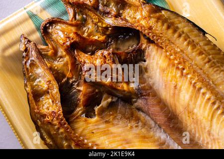 Closeup giapponese Aji no Hiraki (sgombri di cavallo secchi e salati) in un contenitore di cibo. Foto Stock