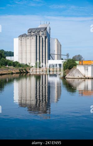 Floreffe, Regione di Wallon, Belgio, 07 28 2022 - stoccaggio industriale di silo e magazzini che si riflettono sulle rive del fiume Sambre Foto Stock