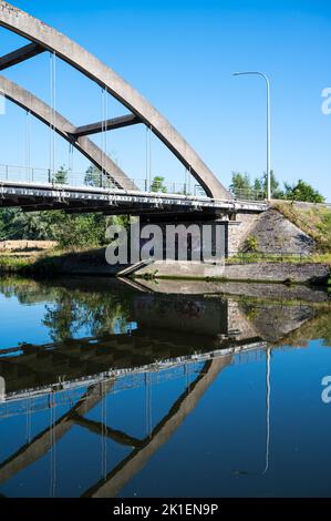 Namur, Regione di Wallon, Belgio, 07 28 2022 - Ponte ferroviario che riflette nelle acque blu del fiume Sambre Foto Stock