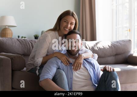 Felice coppia di giovani in posa nel soggiorno Foto Stock