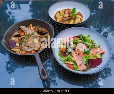 bistecca ripiena di crema, costolette di vitello alla griglia di agnello su un piatto con patate al forno, cena in spiaggia Foto Stock