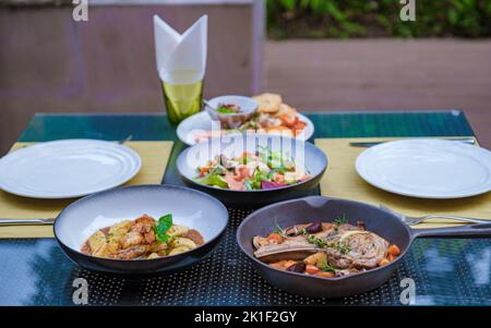 bistecca ripiena di crema, costolette di vitello alla griglia di agnello su un piatto con patate al forno, cena in spiaggia Foto Stock