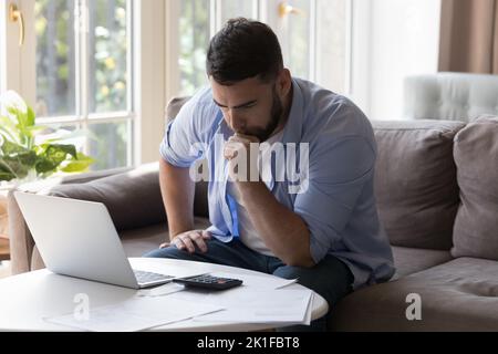 Serio interessato uomo d'affari che analizza la perdita finanziaria nel paese Foto Stock