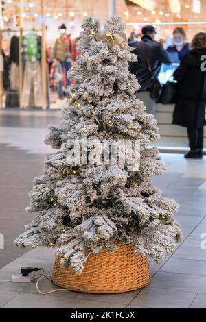 Albero di Natale in negozio a europea. Decorazioni natalizie preparate per la vendita nel centro commerciale. Varietà di decorazioni bianche. Foto Stock