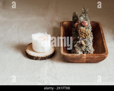 Incenso per fumigazione, rami in mazzo di fiori secchi, aroma bruciante su aromaterapia e candele bianche e meditazione con candele sul tavolo Foto Stock