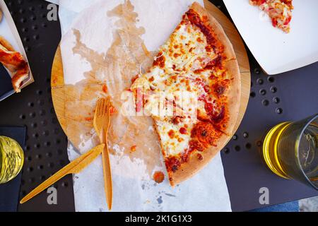 Tradizionale e autentica pizza italiana cotta nel forno a legna. Su tavola con ingredienti. Foto Stock