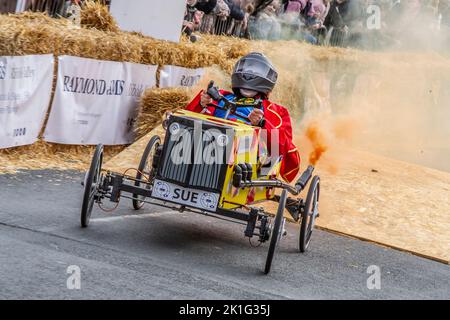 SUE con scarico pirotecnico a fiamma in Longridge, Preston. UK News 18 Settembre 2022; evento di beneficenza della comunità Soapbox Derby che si svolge nel cuore del villaggio. Una giornata di “divertimento per tutta la famiglia, corse, costumi e carri stravaganti, emozioni e sversamenti” ha attirato migliaia di visitatori nella strada principale della città. I veicoli di legno, senza motore e fatti a mano, si sono arroccati lungo Berry Lane mentre la strada principale del villaggio è stata convertita in un circuito di corsa insolito per il giorno. L'evento è stato organizzato per raccogliere fondi vitali per l'azione comunitaria di beneficenza locale Longridge. 'Credit ; MediaWorldImages/Alamy LiveNews Foto Stock