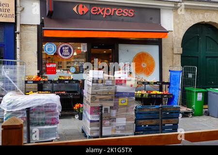 Articoli per la consegna del cibo seduti sul marciapiede, in attesa di essere simballati e collocati sugli scaffali, Carrefour Express, 6th Arrondissement, Parigi, Francia. Foto Stock