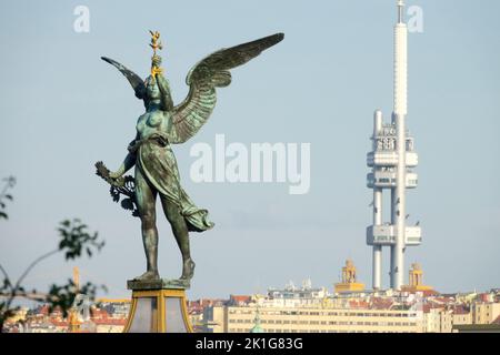 Statua dell'Angelo di Praga in cima a una colonna sul Ponte Cechuv Most a Praga Repubblica Ceca sfondo Zizkov torre della TV Foto Stock