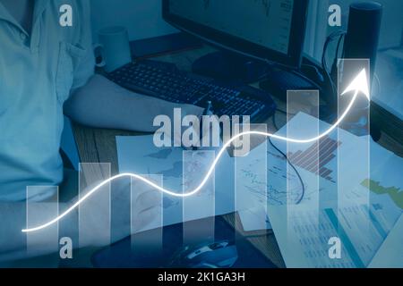 Un uomo caucasico che studia carte con mappe, grafici e grafici. Economia concettuale, sviluppo, globalizzazione. Foto Stock