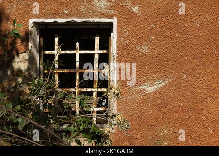 Finestra di una vecchia prigione in rovina con sfondo per il testo. Foto Stock