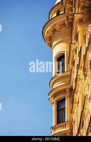 Vecchio edificio giallo con finestre e cielo blu Foto Stock