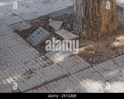 piastrelle del marciapiede irregolari. Buche, insicurezza e rischio Foto Stock