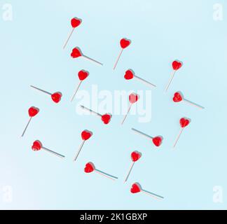 Lollipop a cuore rosso su sfondo blu pallido. Concetto minimo. Foto Stock