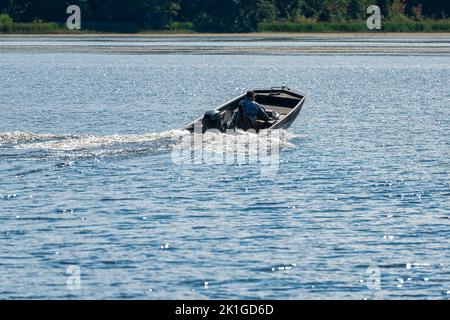 Uomo in una barca da pesca che si dirige verso il fiume per catturare pesci, sul lago Guntersville in Scottsboro Alabama. Foto Stock