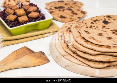 Tradizionale flatbread vegano a grano intero. Frittelle salate fatte in casa servite con cavolo rosso e tempeh. Versione sana del cibo tradizionale slovacco. Foto Stock