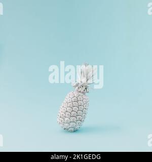 Ananas colorato in bianco bilanciamento su sfondo blu. Concetto estivo minimale. Foto Stock