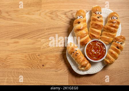 Le salsicce mummy spaventano Halloween festa decorazione alimentare avvolto in pasta Foto Stock