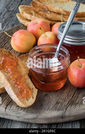 Gelatina di mele di granchio fatta in casa spalmata su pane tostato, pronto per mangiare. Foto Stock