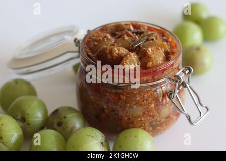 La Pickle di amla o il sottaceto di uva spina immagazzinato in una bottiglia di vetro. È un condimento piccante fatto con Amla anche conosciuto come uva indiana, peperoncino rosso in polvere Foto Stock