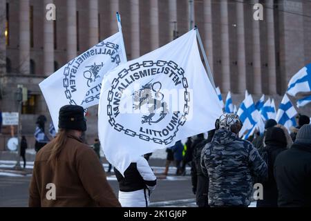 Helsinki, Finlandia - 6 dicembre 2021: Manifestanti che trasportano bandiere Kansallismielisten liittouma (alleanza nazionalista) all'etnonational di estrema destra Foto Stock